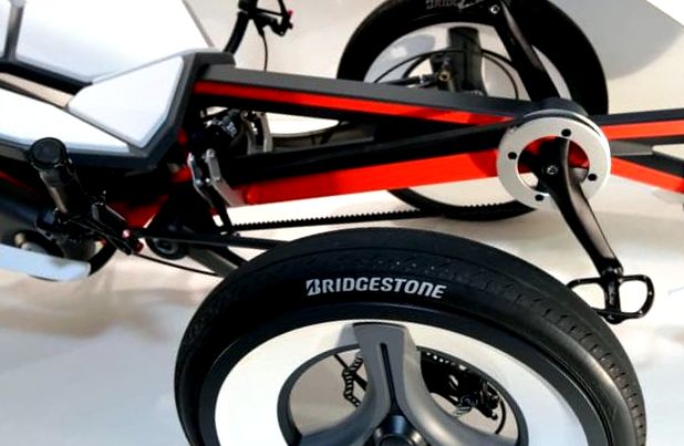  Bridgestone' /></div>Unitatea electrică de acționare este integrată în brațul oscilant al suspensiei roții din spate - similar cu ceea ce se face acum în scuterele ușoare pe benzină.</p>
<p><div style=